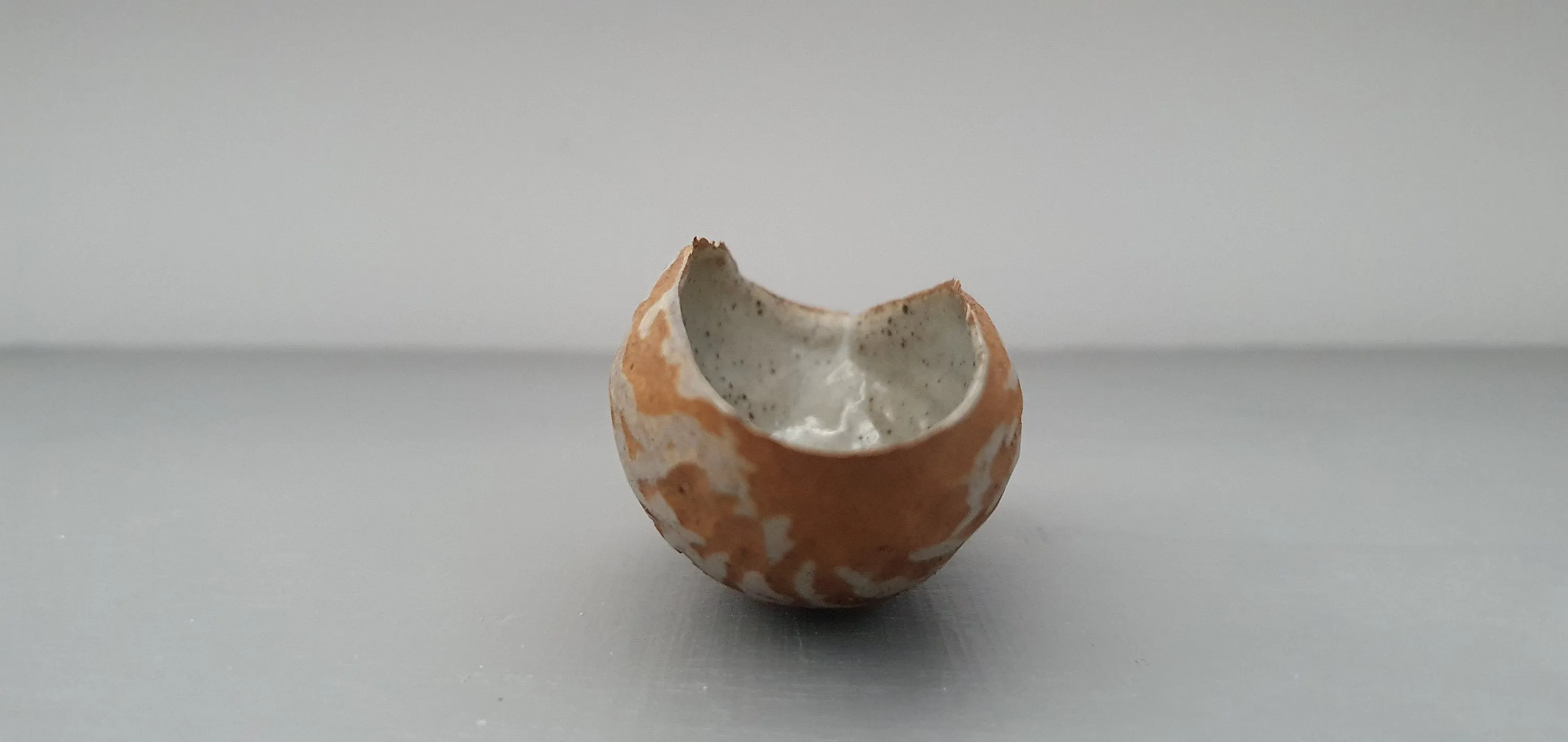Hand curled big walnut shell in earthy woody colour in stoneware with clear glossy interior