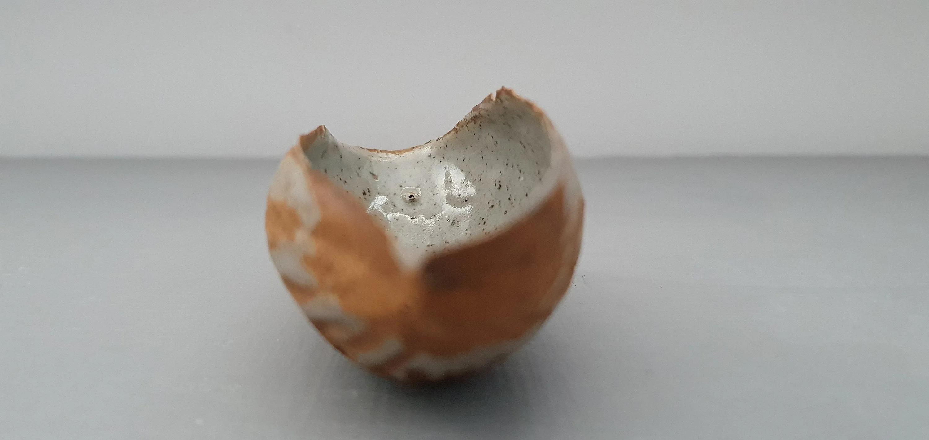 Hand curled big walnut shell in earthy woody colour in stoneware with clear glossy interior